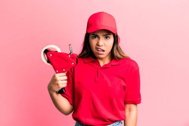 İspanyol güzel kadın şaşkın ve şaşkın hissediyor. paketleyici ve dağıtım çalışanı