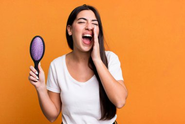 feeling happy,giving a big shout out with hands next to mouth. hair comb concept