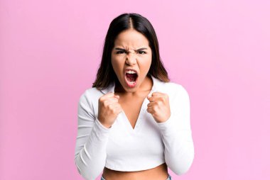 İspanyol asıllı güzel bir kadın sinirli, sinirli bakışlar ve sıkı yumruklar ile agresif bir şekilde bağırıyor.