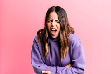 İspanyol güzel bir kadın endişeli, hasta, hasta ve mutsuz hissediyor. Ağrılı bir mide ağrısı veya grip geçiriyor.