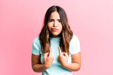 İspanyol asıllı güzel bir kadın, şaşkın ve şaşkın bir bakışla kendini işaret ediyor. Seçildiğine şaşırmış ve şaşırmış.