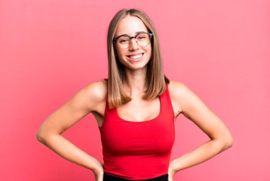 Olumlu, mutlu, kendinden emin ve rahat bir ifadeyle neşeyle gülümsüyor.