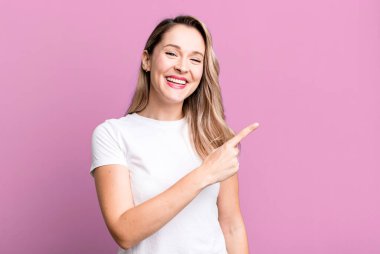 Heyecanlı ve şaşırmış görünüyor. Yana ve yukarıya bakıyor. Boşluğu kopyalıyor.