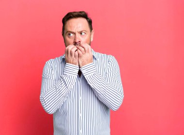 Endişeli, endişeli, stresli ve korkmuş görünüyor, tırnaklarını yiyor ve yanal kopya alanı arıyor.