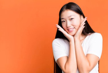 Genç, güzel, Asyalı, etkileyici bir kadın. Yanında fotokopi odası var.