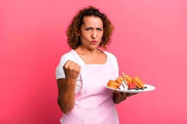 pretty middle age woman feeling angry, annoyed, rebellious and aggressive. home made waffles concept