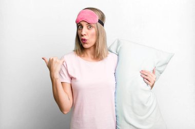 pretty blonde woman looking astonished in disbelief. pajamas and nightwear concept