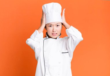 Güzel Asyalı kadın stresli, endişeli ya da korkmuş, elleri başının üstünde. restoran şefi konsepti