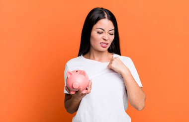 hispanic pretty woman feeling stressed, anxious, tired and frustrated with a piggy bank