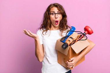 İspanyol güzel kadın şaşırmış ve şok olmuş görünüyor. Çenesi düşmüş, elinde alet çantasıyla bir nesne tutuyor. Becerikli adam kavramı