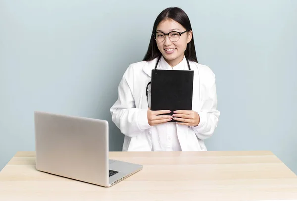 young adult pretty asian physician woman on a desk with a laptop