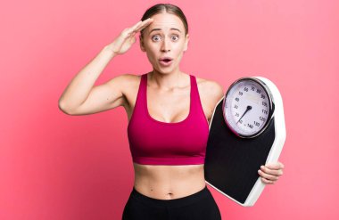 caucasian pretty woman looking happy, astonished and surprised. fitness and diet concept