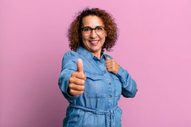 Orta yaşlı İspanyol kadın gururlu, kaygısız, kendinden emin ve mutlu, olumlu gülümsüyor.