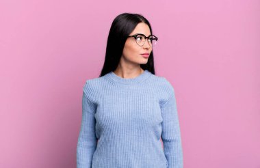 Endişeli, kafası karışık, budala bir ifadeyle, kopya alanı arayan, şüphe duyan güzel Latin bir kadın.