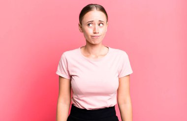 Şaşırmış ve kafası karışmış görünüyor, merak ediyor ya da bir sorunu çözmeye çalışıyor.