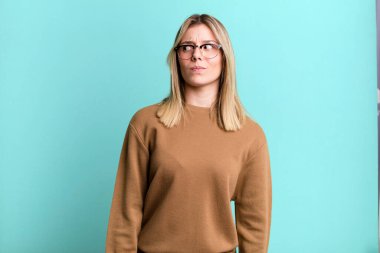 Sarışın, güzel bir kadın mutlu düşünceler ve fikirler düşünüyor, hayal kuruyor, kenarda yer arıyor.