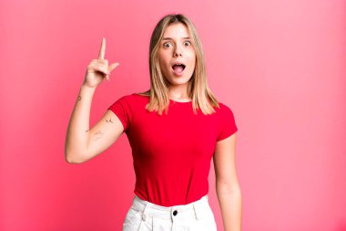 Sarışın, güzel bir kadın bir fikri fark ettikten sonra mutlu ve heyecanlı bir dahi gibi hissediyor. Neşeli bir şekilde parmağını kaldırıyor.!