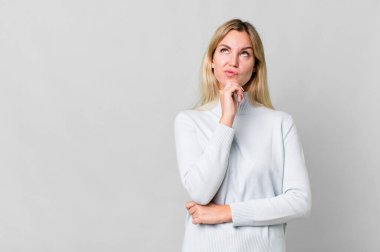 caucasian blonde woman thinking, feeling doubtful and confused. copy space concept