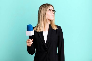 Profil görünümlü genç, güzel bir kadın hayal kuruyor ya da hayal kuruyor. sunucu veya gazeteci kavramı