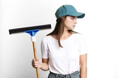 Profil görünümlü genç, güzel bir kadın hayal kuruyor ya da hayal kuruyor. Pencere temizleme kavramı