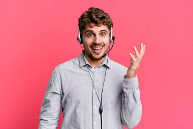 Genç, beyaz bir adam kendini mutlu hissediyor. Bir çözüm ya da fikir bulduğuna şaşırıyor. tele pazarlamacı ajan konsepti