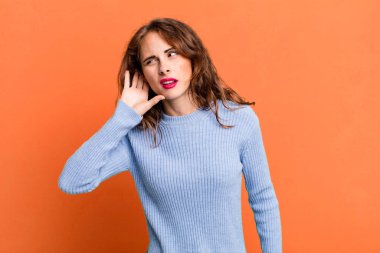 Genç ve güzel bir kadın ciddi ve meraklı görünüyor, dinliyor, gizli bir konuşma veya dedikodu duymaya çalışıyor, kulak misafiri oluyor.