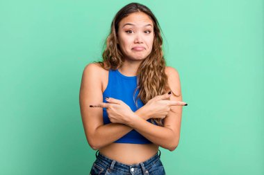 Kafası karışmış, güvensiz ve şüpheyle zıt yönlere bakan güzel bir kadın.