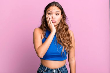 Genç, güzel bir kadın, ağzı açık bir şekilde yüz yüze inanmayarak şok olmuş ve hayrete düşmüş hissediyor.