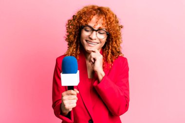 Kızıl saçlı, güzel bir kadın mutlu, kendinden emin, elleri çenesinde gülümsüyor. gazeteci ve sunucu kavramı