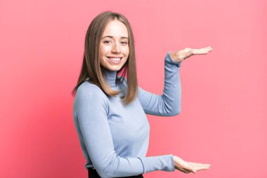 gülümseyen, mutlu, pozitif ve tatmin olmuş hisseden, kopya uzayı üzerinde nesne veya konsept tutan veya gösteren