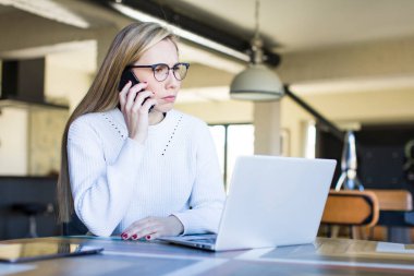 young adult pretty blonde woman using her laptop al home