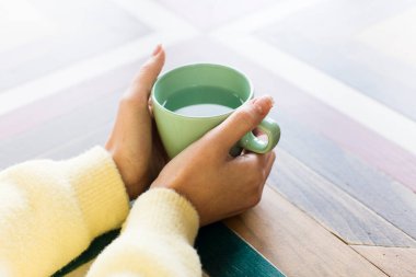 woman holding water cup on a table