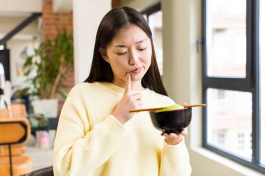 asian pretty woman eating a ramen noodles bowl