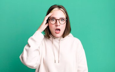 Genç, güzel bir kadın mutlu, şaşkın ve şaşırmış görünüyor.