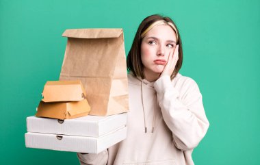 young pretty woman feeling bored, frustrated and sleepy after a tiresome. take away fast food concept