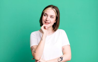 Genç ve güzel bir kadın mutlu, kendinden emin bir ifadeyle gülümsüyor.