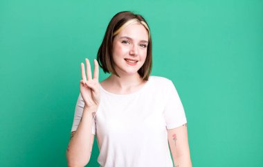 Genç, güzel bir bayan gülümsüyor ve arkadaş canlısı görünüyor.