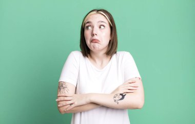 Genç, güzel bir kadın omuz silkiyor, kafası karışık ve kararsız.