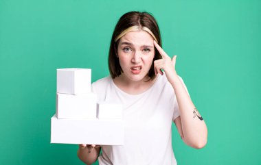 young pretty woman feeling confused and puzzled, showing you are insane. white blank boxes
