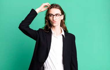 Genç, güzel bir kadın kafası karışmış, kafası karışmış, kaşınıyor. iş kavramı