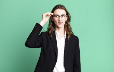 Genç ve güzel bir kadın kafası karışık ve şaşkın hissediyor, deli olduğunu gösteriyor. iş kavramı