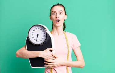 Genç ve güzel bir kadın çok şaşırmış ya da şaşkın görünüyor. fitness ve diyet konsepti