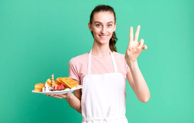 Gülümseyen ve mutlu görünen genç, güzel bir kadın zafer ya da huzur simgesi. Waffle konsepti