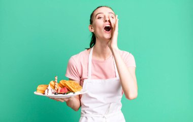 Genç, güzel bir kadın kendini mutlu hissediyor. Elleri ağzının kenarında bağırıyor. Waffle konsepti