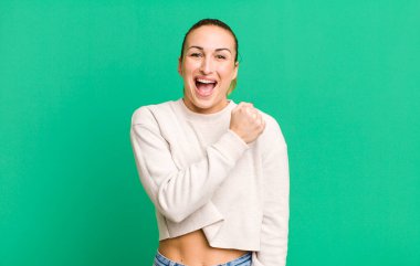 Genç ve güzel bir kadın kendini mutlu hissediyor ve bir meydan okumayla yüzleşiyor veya kutluyor