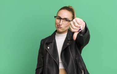 Gülümseyen ve mutlu görünen genç güzel bir kadın zafer ya da barış işareti yapıyor.