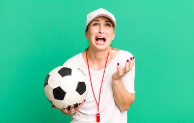 young pretty woman looking desperate, frustrated and stressed. soccer coach concept