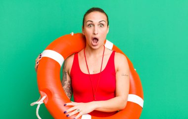 young pretty woman looking very shocked or surprised. summer and lifeguard concept