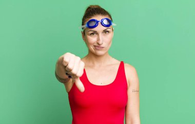 young pretty woman feeling cross,showing thumbs down. swimmer concept