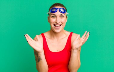young pretty woman feeling happy and astonished at something unbelievable. swimmer concept